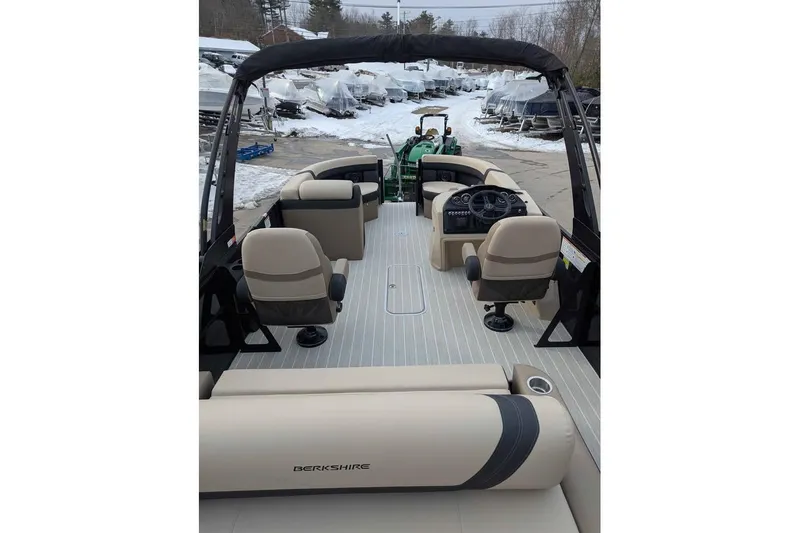 Slide: The Image of 2026 Berkshire 24UL CTS pontoon boat interior with beige seating and steering console. - 8