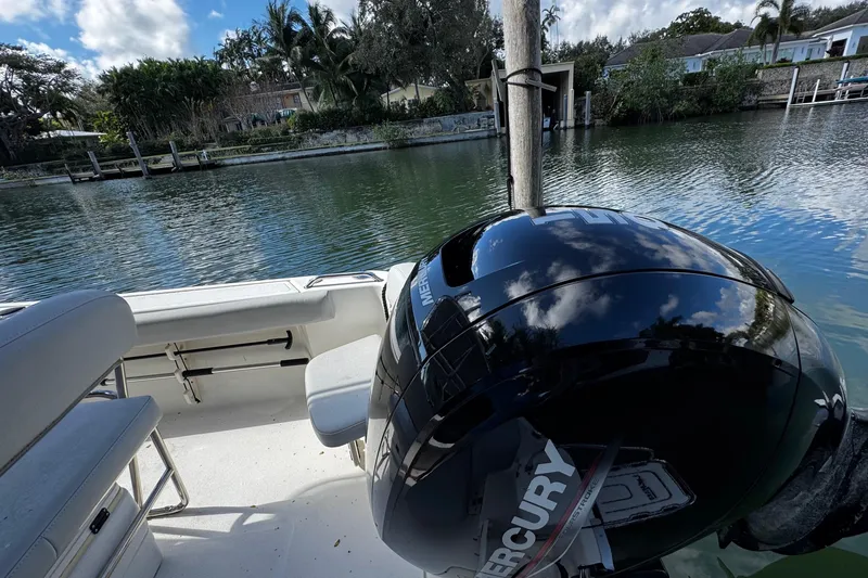 Slide: The Image of 2018 Mako 204 Center Console boat with Mercury engine on a calm waterway. - 11