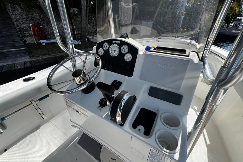 Slide: The Image of 2018 Mako 204 Center Console boat dashboard with steering wheel and controls. - 14
