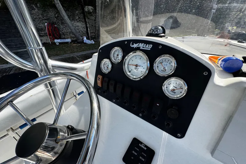 Slide: The Image of 2018 Mako 204 Center Console boat dashboard with gauges and steering wheel. - 15