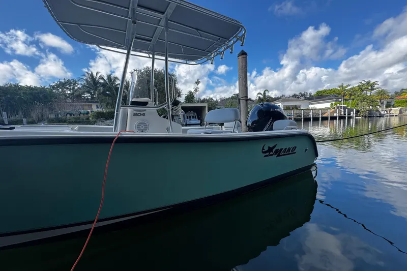Slide: The Image of 2018 Mako 204 Center Console boat docked on a sunny day. - 2