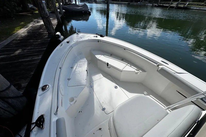 Slide: The Image of 2018 Mako 204 Center Console boat docked by a serene waterfront. - 4