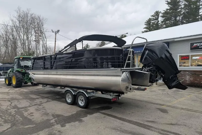Slide: The Image of 2026 Berkshire 24RFX LE pontoon boat on trailer, parked outdoors near a tractor. - 4