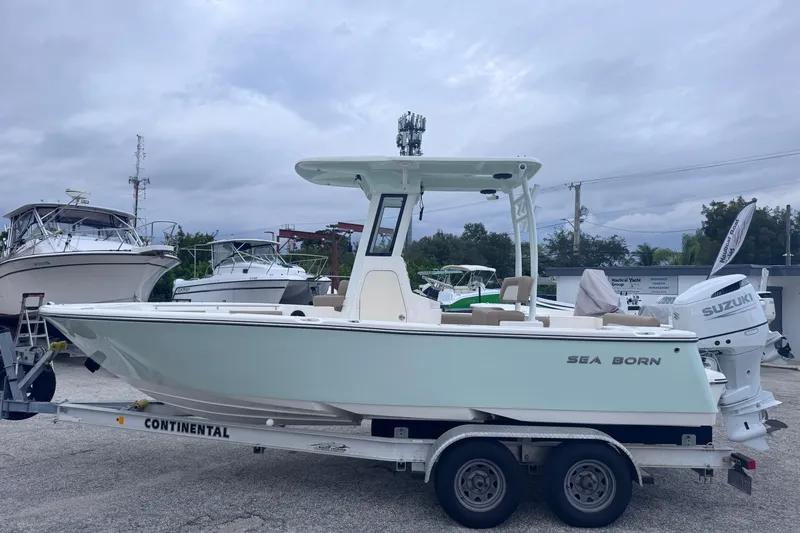 The Image of 2026 Sea Born LX22 Center Console boat on trailer, parked outdoors. - 0