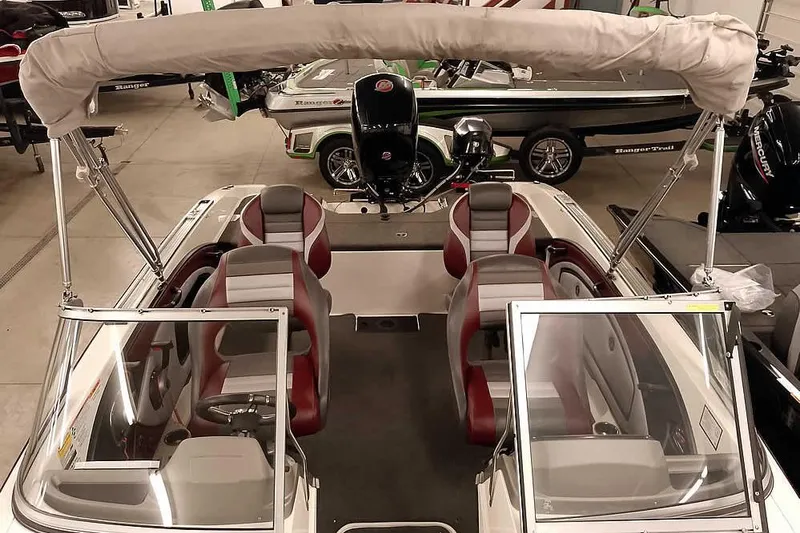 Slide: The Image of 2020 Ranger 1850MS Reata boat with bimini top and seating, displayed indoors. - 30