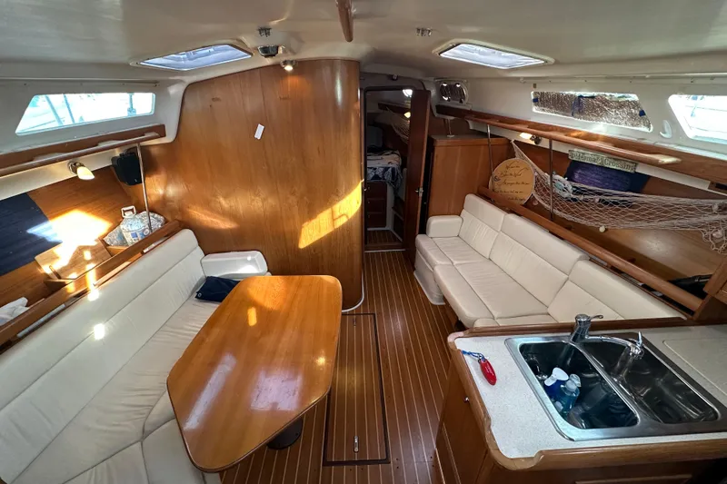 Slide: The Image of Interior of a 2003 Catalina 350 sailboat with wood finish and white seating. - 10