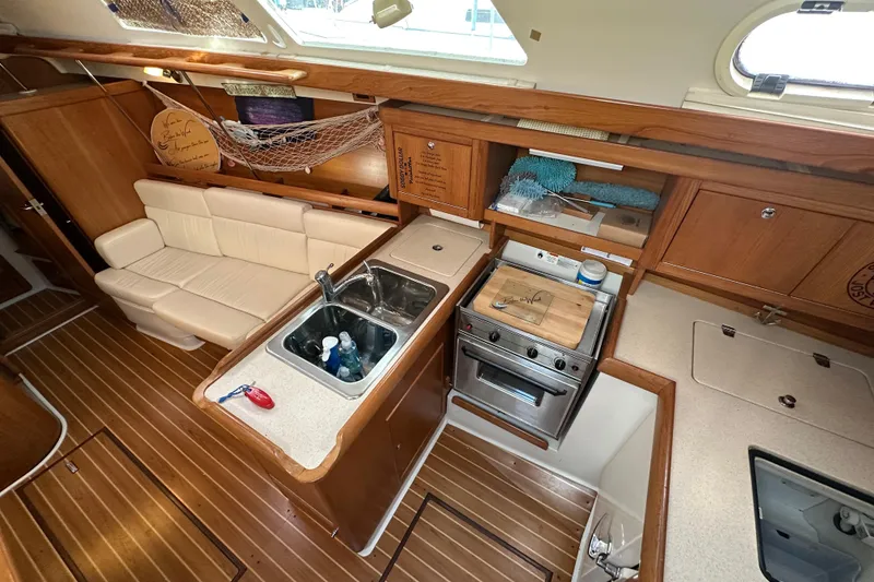 Slide: The Image of Interior of 2003 Catalina 350 sailboat with kitchen and seating area. - 11