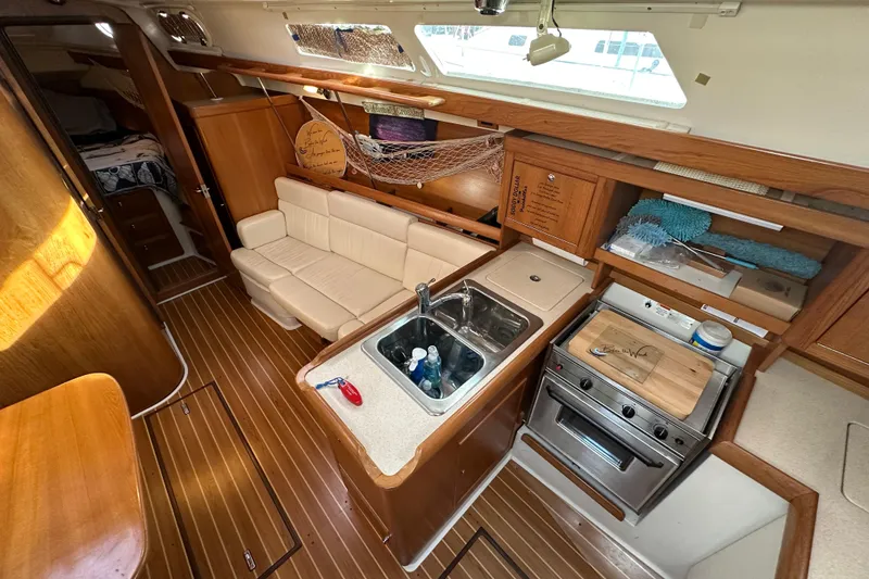 Slide: The Image of Interior of 2003 Catalina 350 sailboat with kitchen and seating area. - 12