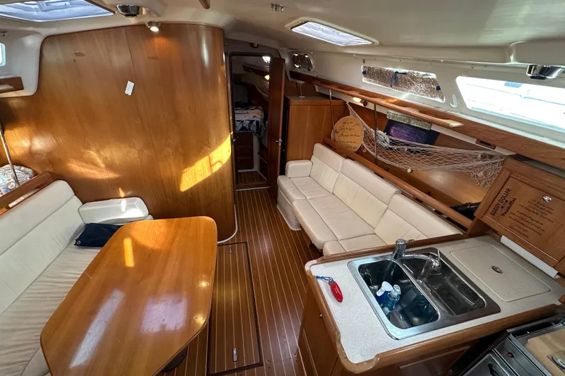 Slide: The Image of Interior of 2003 Catalina 350 sailboat with wood finish and cozy seating area. - 13