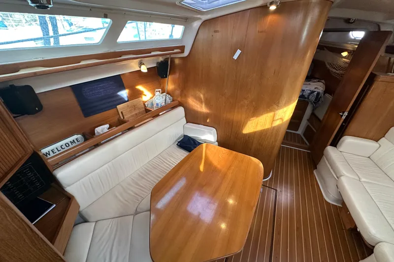Slide: The Image of Interior of 2003 Catalina 350 sailboat with wooden finishes and cozy seating area. - 14