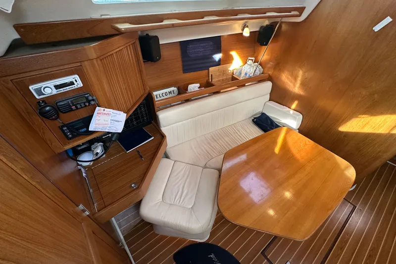 Slide: The Image of Interior of a 2003 Catalina 350 sailboat with wooden table and seating area. - 15