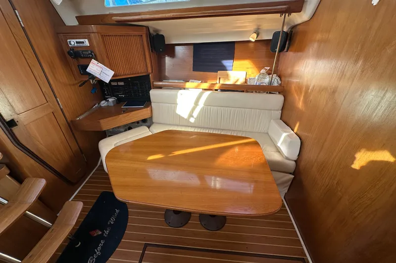 Slide: The Image of Cozy interior of 2003 Catalina 350 sailboat with wooden table and seating area. - 18