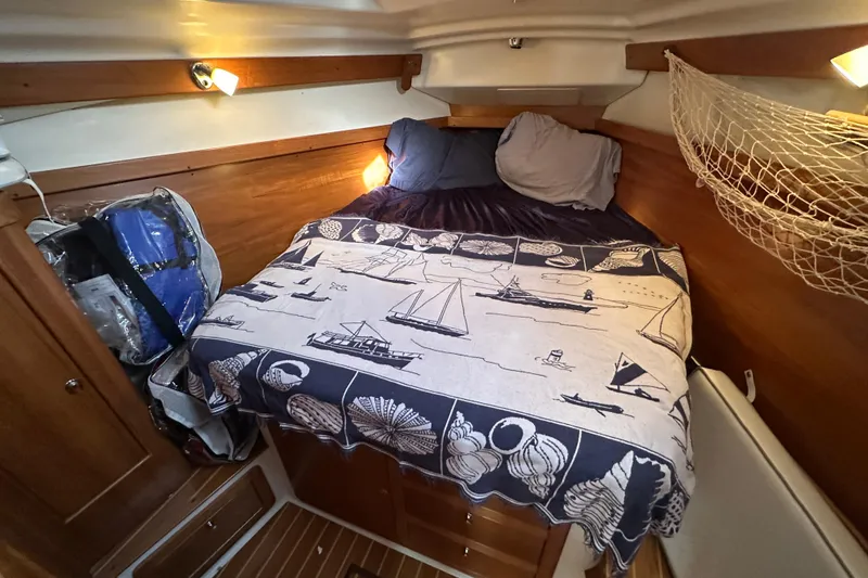 Slide: The Image of Cozy cabin interior of 2003 Catalina 350 sailboat with nautical-themed bedding. - 21