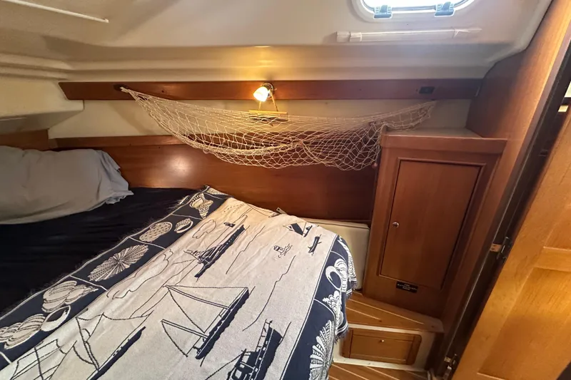 Slide: The Image of Cozy cabin interior of 2003 Catalina 350 sailboat with nautical-themed bedding. - 24