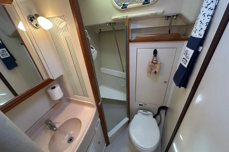Slide: The Image of Bathroom interior of a 2003 Catalina 350 sailboat, featuring sink, toilet, and shower. - 26