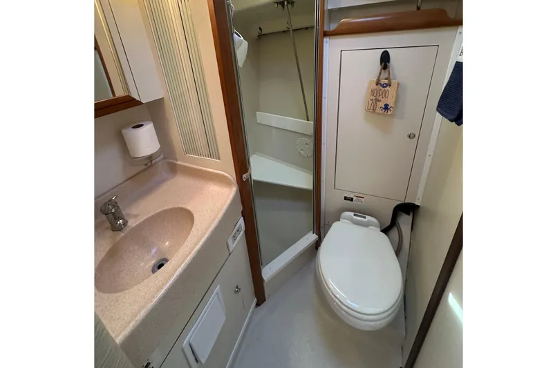 Slide: The Image of 2003 Catalina 350 yacht bathroom with sink, toilet, and shower area. - 27
