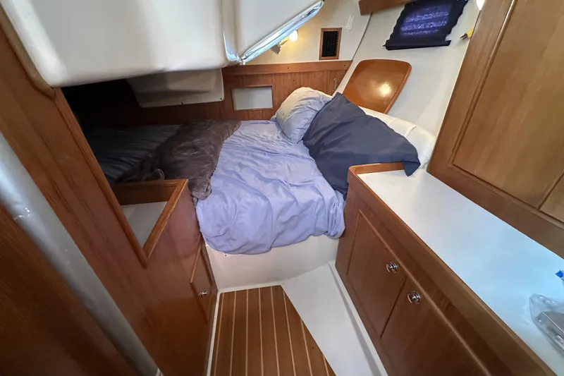 Slide: The Image of Cozy cabin interior of 2003 Catalina 350 sailboat with wooden furnishings and comfortable bedding. - 29