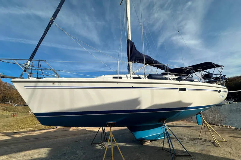 Slide: The Image of 2003 Catalina 350 sailboat docked at marina, showcasing deck and rigging details. - 3