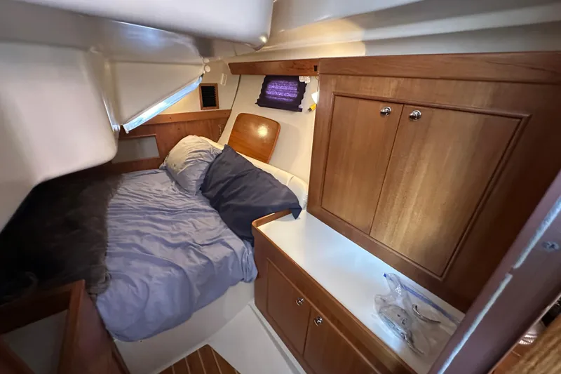 Slide: The Image of Cozy cabin interior of 2003 Catalina 350 sailboat with wooden cabinetry and comfortable bedding. - 30