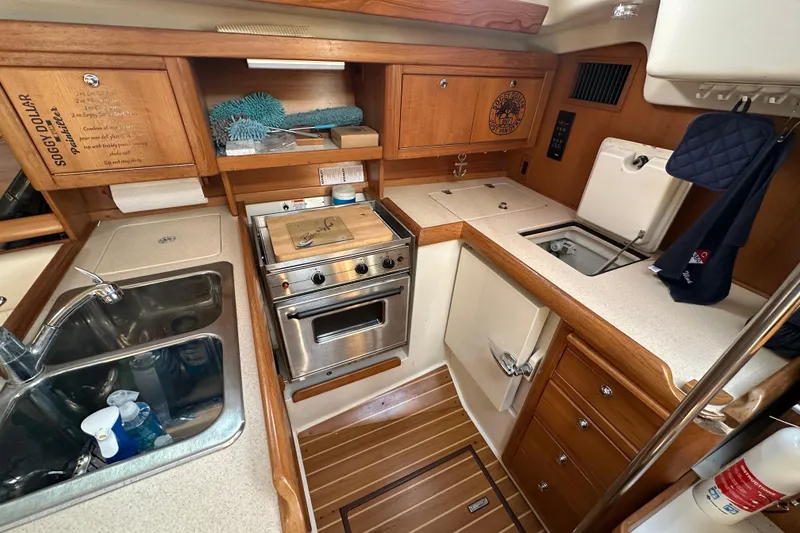 Slide: The Image of Compact kitchen in a 2003 Catalina 350 sailboat with wooden cabinetry and stainless steel sink. - 34