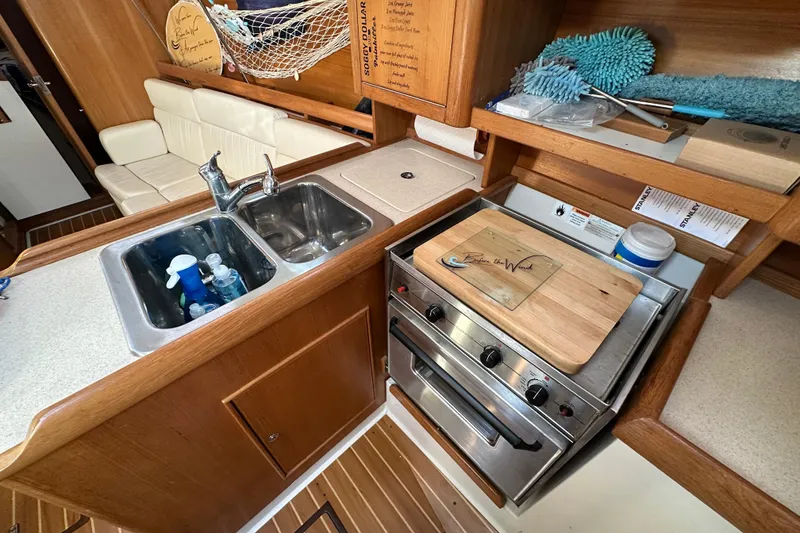 Slide: The Image of 2003 Catalina 350 yacht kitchen with sink, stove, and wooden cabinetry. - 39