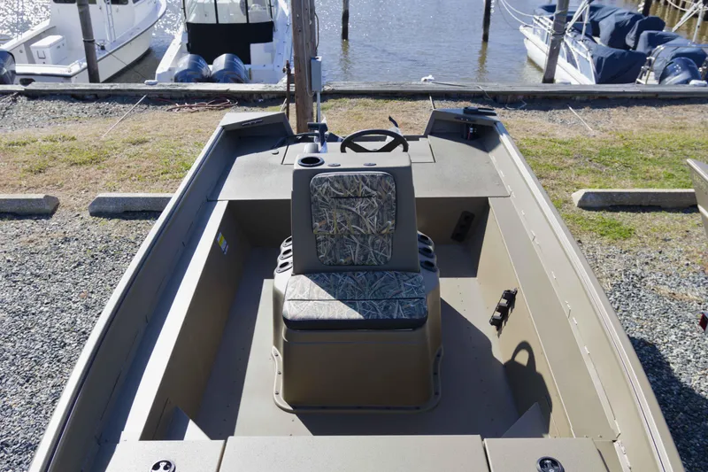 Slide: The Image of 2026 G3 Gator Tough 17 CC boat interior with camo seat, docked by the water. - 10