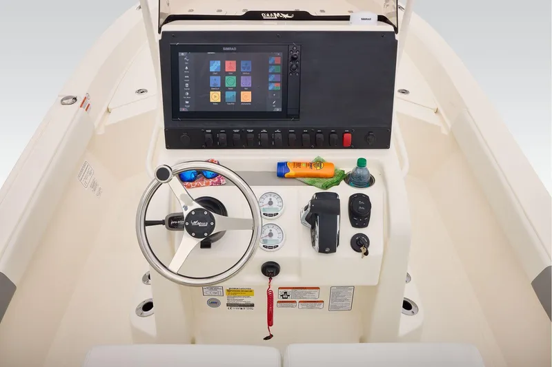 Slide: The Image of 2026 Mako 24 APEX boat dashboard with steering wheel, controls, and touchscreen display. - 28