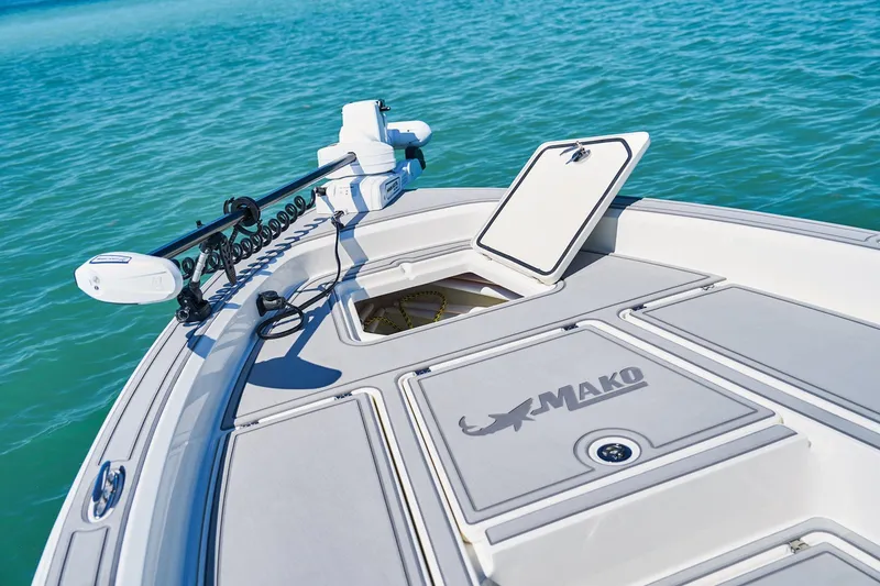 Slide: The Image of 2026 Mako 24 APEX boat deck with open hatch on turquoise water. - 65