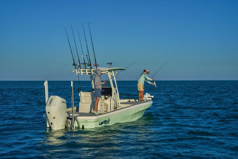 Slide: The Image of Two people fishing on a 2026 Mako 24 APEX boat in open water. - 79