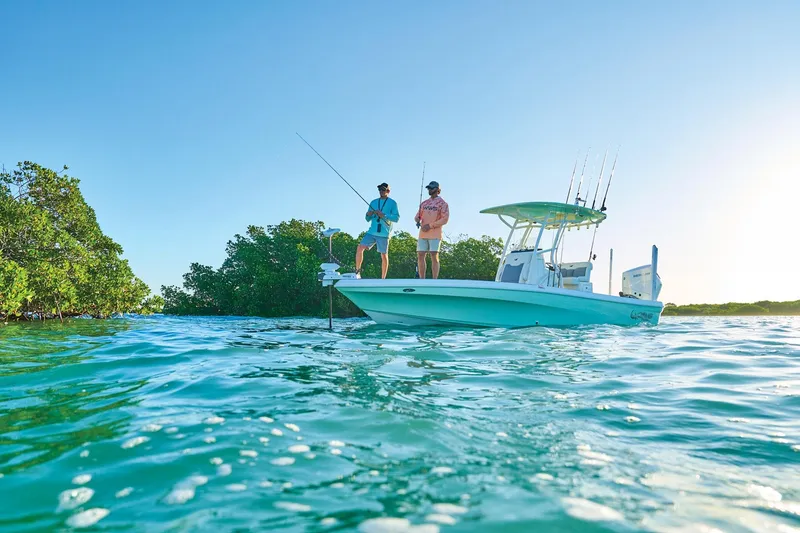 Slide: The Image of 2026 Mako 24 APEX boat with anglers fishing in clear blue waters. - 57