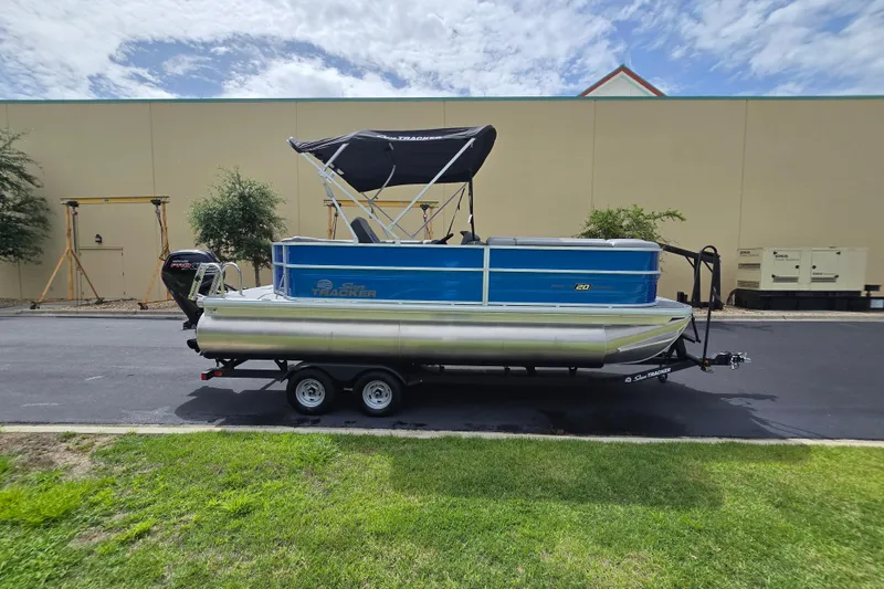 Slide: The Image of 2026 Sun Tracker Party Barge 20 DLX pontoon boat on trailer, parked outdoors. - 3