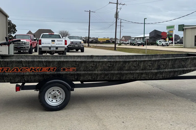 The Image of 2026 Tracker Grizzly 15 Jon boat on trailer, parked in industrial area. - 0