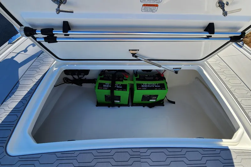 Slide: The Image of Open storage compartment of 2026 Mako 18 Pro Skiff with green batteries inside. - 10