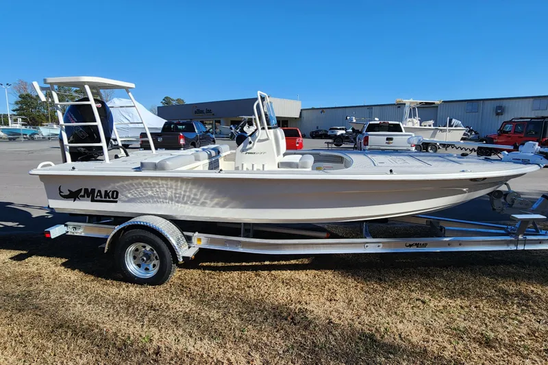 Slide: The Image of 2026 Mako 18 Pro Skiff boat on trailer, parked outdoors in a dealership lot. - 5