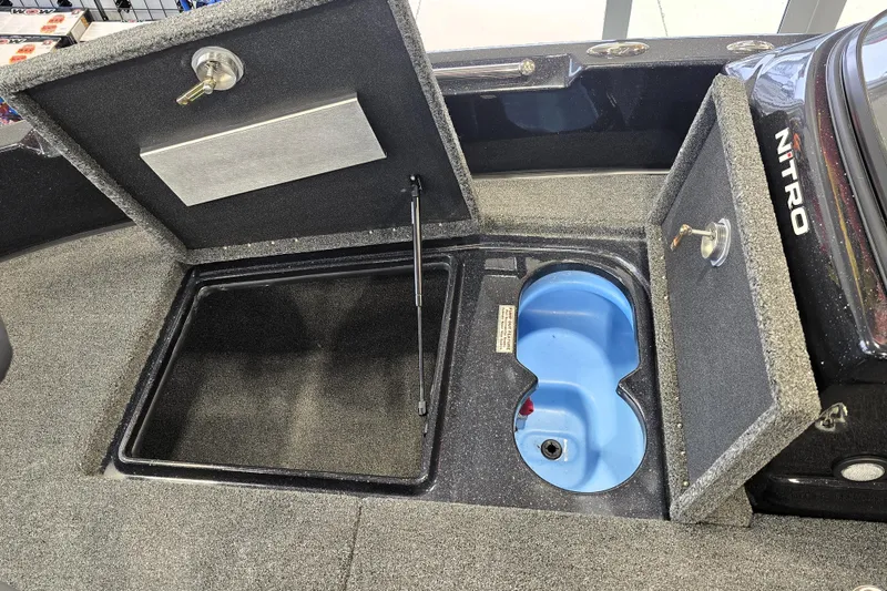 Slide: The Image of 2026 Nitro ZV19 Sport Pro boat storage compartments with carpeted interior and blue livewell. - 73