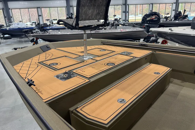 Slide: The Image of 2026 Avid 20 Rogue CC boat interior with wooden deck and seating in showroom. - 19