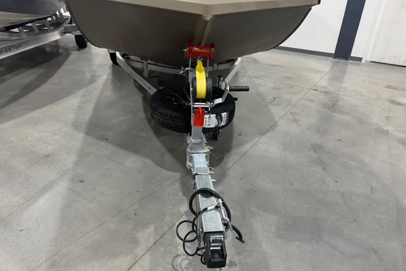 Slide: The Image of 2026 Avid 20 Rogue CC boat trailer with winch and spare tire in a showroom. - 30