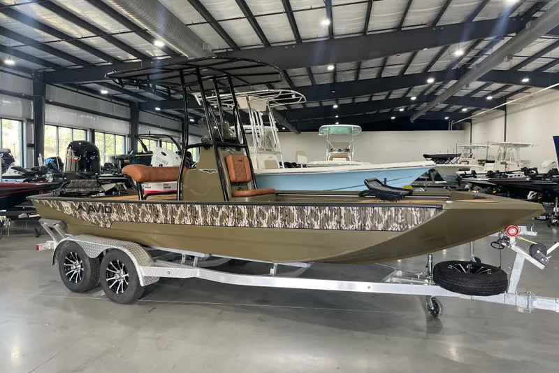 Slide: The Image of 2026 Avid 20 ROGUE CC boat in showroom, featuring camouflage design and dual-axle trailer. - 9