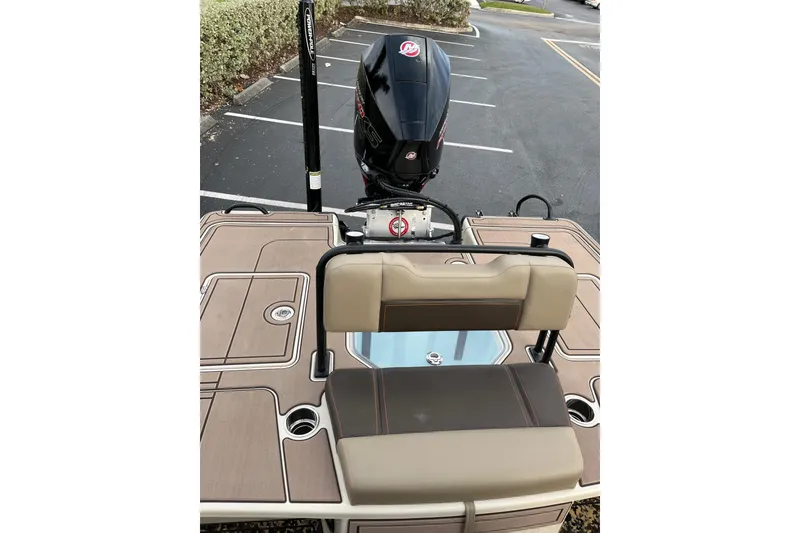 Slide: The Image of 2026 Mako 18 Pro Skiff Backwater Edition boat with seating and motor in parking lot. - 11