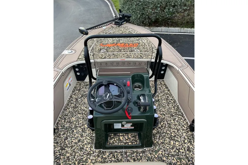 Slide: The Image of 2026 Mako 18 Pro Skiff Backwater Edition boat interior with camo design and steering console. - 7