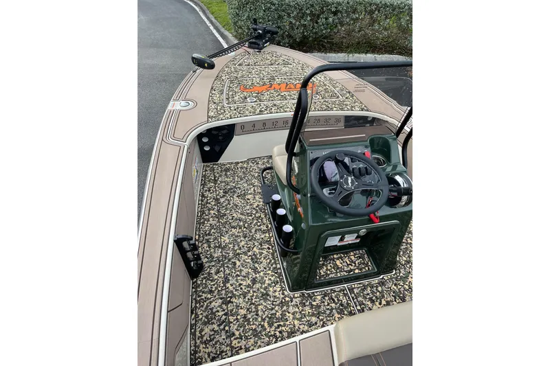 Slide: The Image of 2026 Mako 18 Pro Skiff Backwater Edition boat interior with camouflage design and steering console. - 9