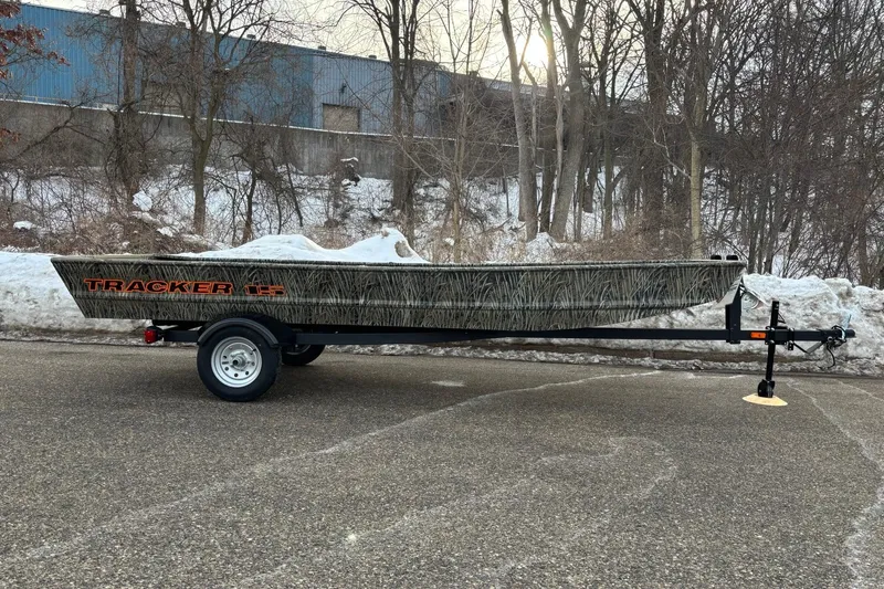 The Image of 2026 Tracker Grizzly 15 Jon boat on trailer, parked on snowy road. - 0