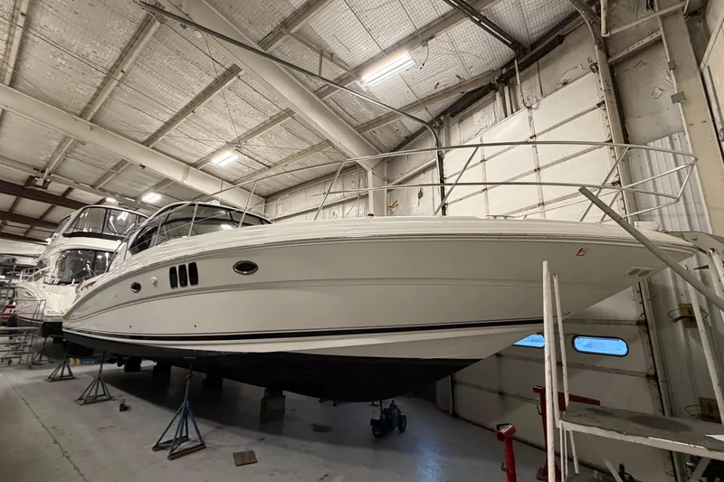 The Image of 2006 Sea Ray 44 Sundancer yacht in indoor storage, elevated on stands. - 0