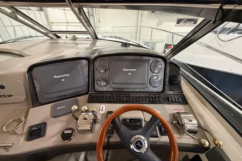 Slide: The Image of 2006 Sea Ray 44 Sundancer helm with Raymarine navigation system and wooden steering wheel. - 9