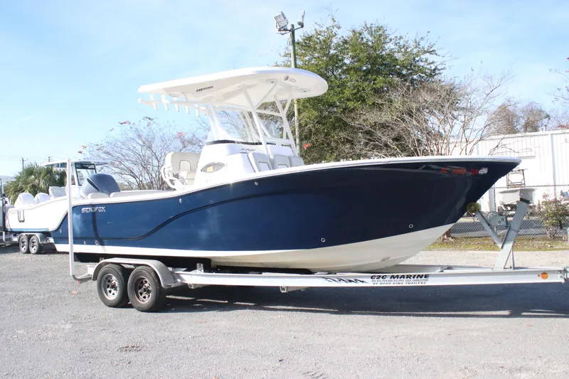 Slide: The Image of 2021 Sea Fox 249 Avenger boat on trailer, blue hull, parked outdoors. - 1