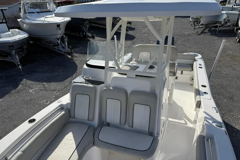 Slide: The Image of 2021 Sea Fox 249 Avenger boat with seating and T-top, parked among other boats. - 9
