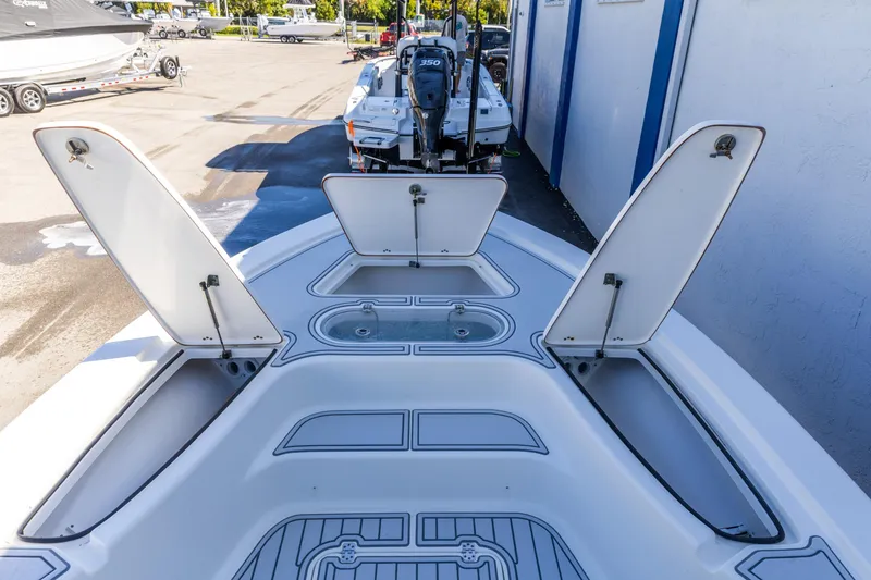 Slide: The Image of 2017 Sea Pro 248 Bay boat with open storage compartments and visible engine. - 17