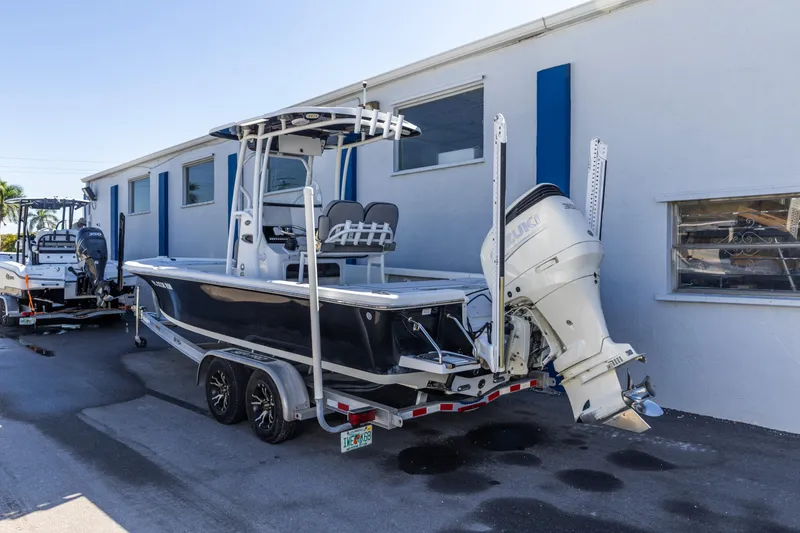 Slide: The Image of 2017 Sea Pro 248 Bay boat with Suzuki outboard motor on trailer, parked beside building. - 3