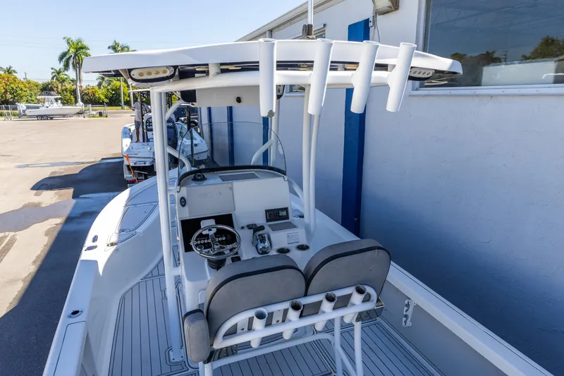 Slide: The Image of 2017 Sea Pro 248 Bay boat with center console and rod holders, parked outdoors. - 6