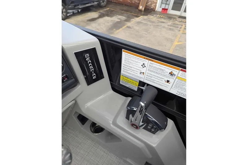Slide: The Image of Control panel of 2026 Berkshire 24RFX CTS boat with throttle and warning labels. - 14